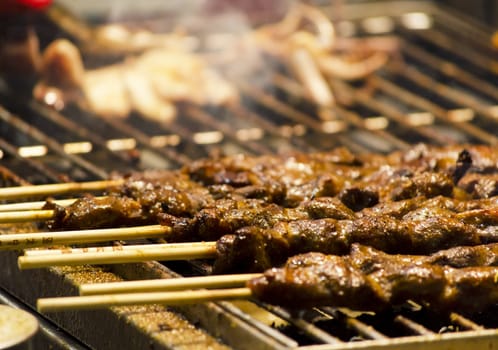 a local cooking meat skewers over charcoal