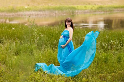 young fashion pregnant girl in a long dress