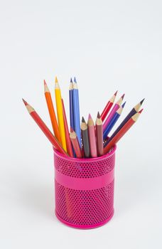 Colour pencils in pink can on white background