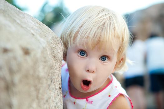 portrait of a surprised girl by the stone 