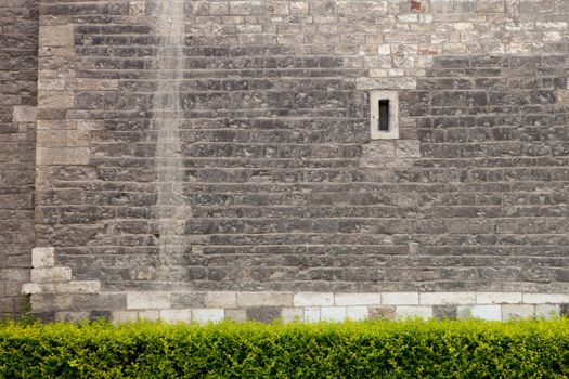 old stone wall with small window