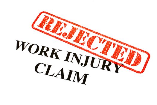 A close-up of a REJECTED Work Injury Claim document.