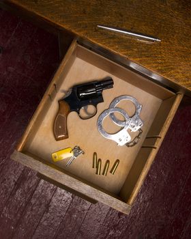 A desk housing pen, a key, ammunition, and handcuffs