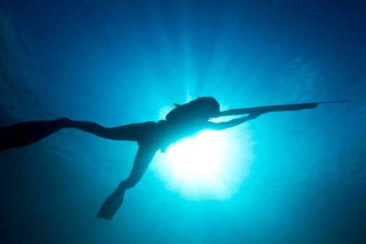 A young woman stalks her prey underwater.