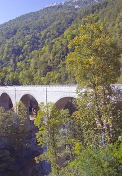 High bridge in between mountains and trees