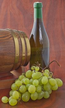 Wine bottle of white wine with barrel and grape