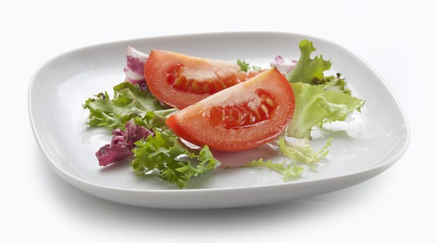 Two pieces of tomato with lettuce on the white plate
