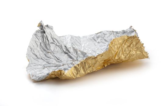 Isolated golden crumpled foil from candy on the white