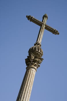 Very old stone cross against the blue sky - Portugal.