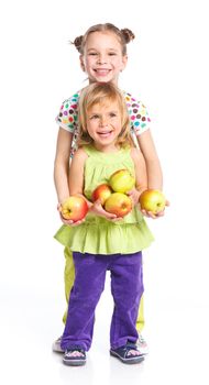 Two happy adorable smiling sisters holding apples. Isolated white background