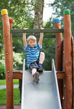 Little blond boy on an outdoor playground