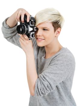 Photo of a beautiful young blond woman holding an old SLR film camera.
