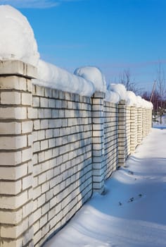 Brick wall, covered with snow in January in rural areas