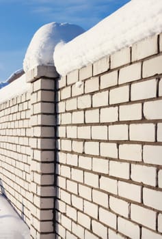 Brick wall, covered with snow  in rural areas