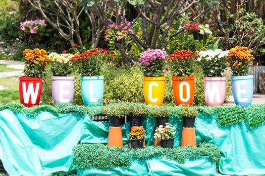 Flower clay pot and painting that welcome message in the garden.