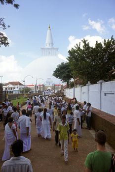 People go to the stupa Ruvanvelisaya. Anuradhapura city. Sri Lanka