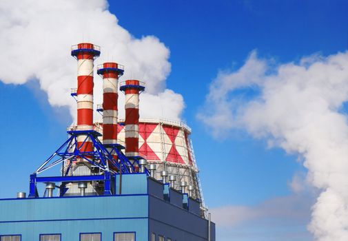 Smoking pipes of gas-turbine plant against blue sky

