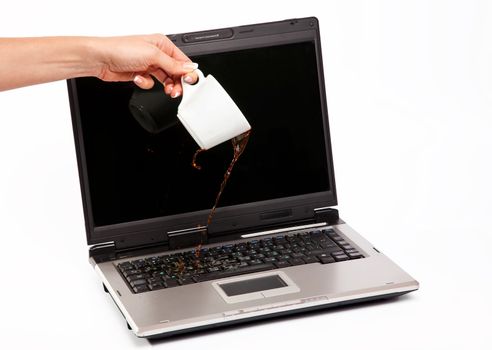 Coffee spilled on laptop keyboard on white background