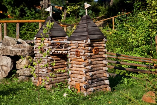 Miniature wooden towers in forest in summer