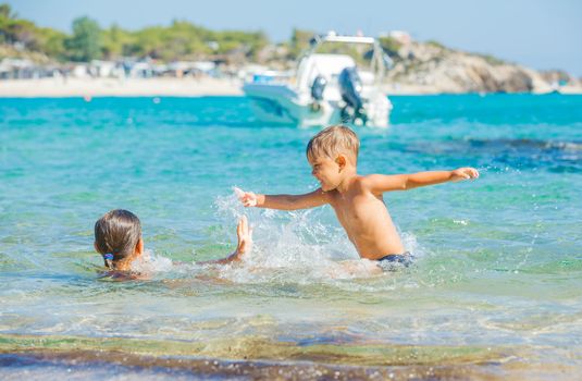 Happy kids. Sister and brother playing and swimming in the transparent sea