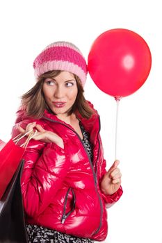Cheerful girl in coat and hat with bag and balloon, isolated on white