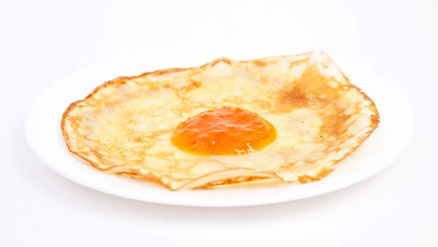 Crepe on white plate with apricot jam