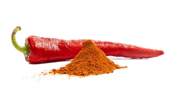 Red chili pepper and pile of red pepper spice isolated on white