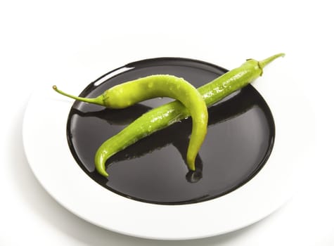 Two green chili peppers on plate