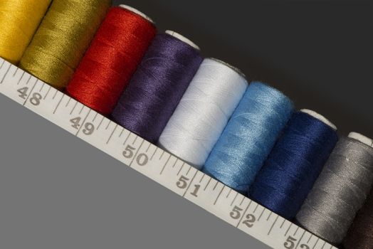 spools of thread of different colours and a tailor's measuring tape