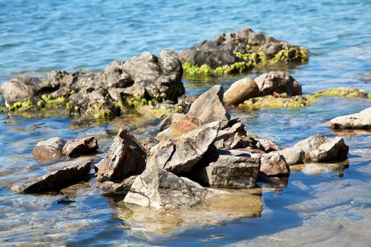 Stones with algae in deep blue sea