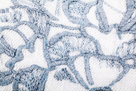 Blue embroidery on white jeans textile