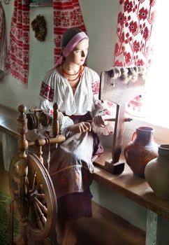 Ukrainian girl waxwork working in traditional interior