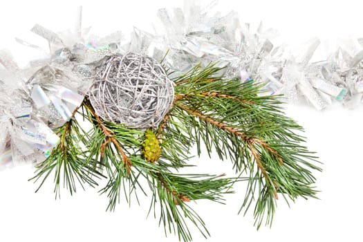 Green conifer branch with silver ball and tinsel isolated on white