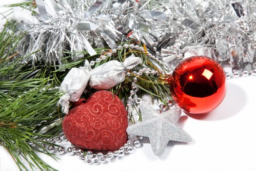 Red Christmas balls and silver star with candy on pine branch