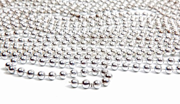 Silver beads on white background with reflection