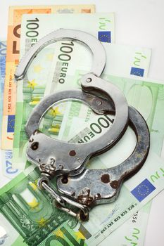 Euro bills and handcuffs close up. Financial Crime and Corruption concept