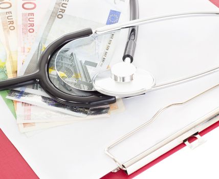 Money and stethoscope on clipboard