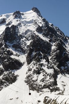 Aiguille du Midi cable car over snow mountain in Chamonix, France.