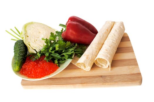 vegetables and greenery with red caviar and lavash on a cutting board