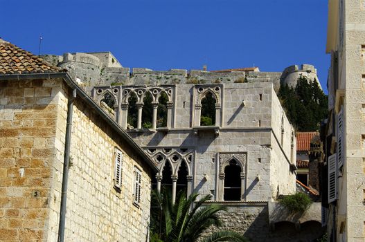 Very old stone house in Hvar, Croatia with fortress on background