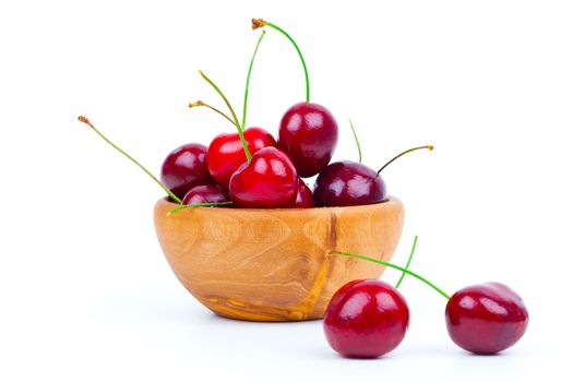 Cherry in wooden bowl isolated on white background