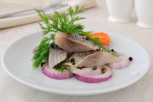 Slices of salted herring fillet with onion and spices