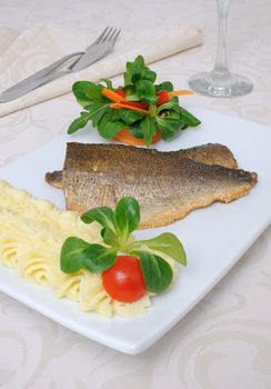 Baked fillet of sea bass with vegetables and mashed potato mix