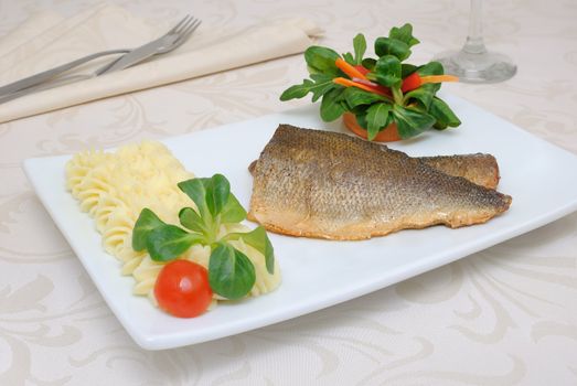 Baked fillet of sea bass with vegetables and mashed potato mix