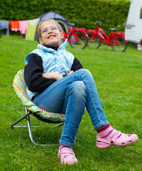 Spring vacation in camping - Cute girl resting in the colorful recliner