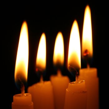 sacred candles in dark on black background