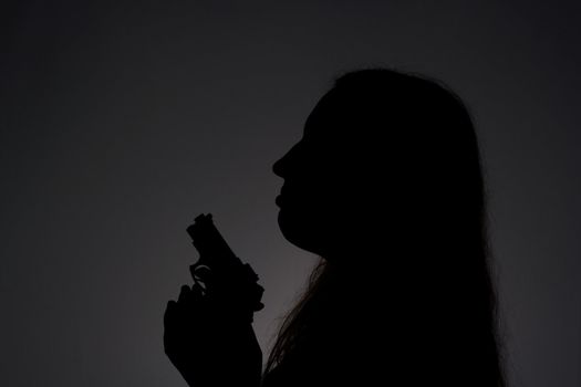 Woman with gun in the darkness