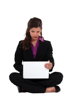 Businesswoman sat barefoot with laptop