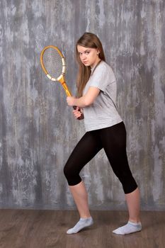 Action portrait of a girl with tennis racket