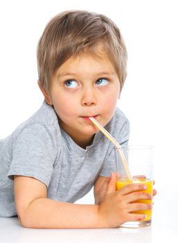 Portrait of happy little boy drinking orange juice. Isolated over white background.
